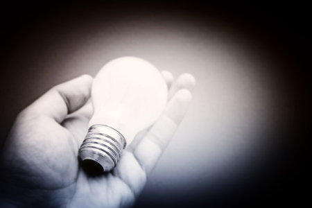 Background with lit lightbulb. Isolated on redの写真素材