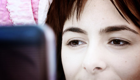 Young woman with laptop in bed .