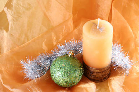 Christmas ball and candle on orange background.の写真素材