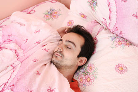 Closeup portrait of a young man sleeping on the bed .の写真素材