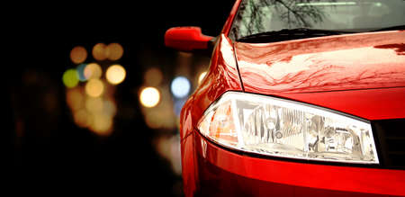 Red car in traffic at nightの写真素材