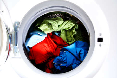 Colorful shirt and trousers in a white laundry.の写真素材