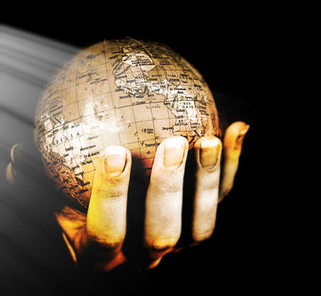 Globe in a girl's hands. Macro image isolated on blackの写真素材