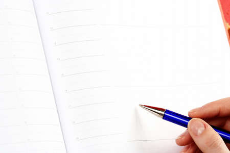 Close-up of woman hand writing in agenda