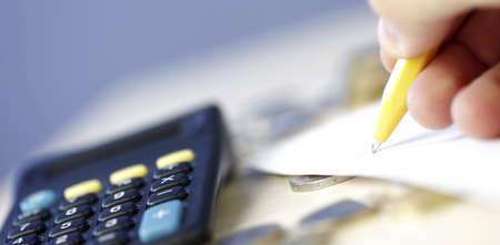 Black computer and coins - Calculating my moneyの写真素材