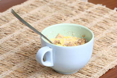 Crunchy breakfast cereals  in a blue bowl with a spoon .