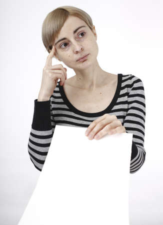 Young blonde woman holding a blank piece of paper.の写真素材