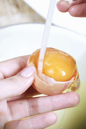 Close-up picture of hands broking eggs.