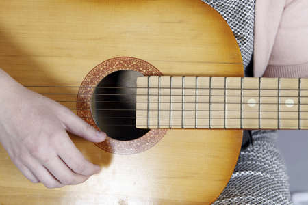 Close up photo of a Young woman playing the guitarの写真素材
