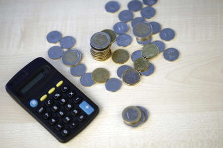 Black computer and coins - Calculating my moneyの写真素材