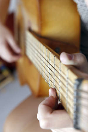 Close up photo of a Young woman playing the guitarの写真素材