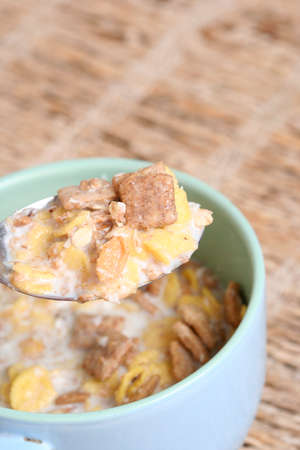 Crunchy breakfast cereals  in a blue bowl with a spoon .