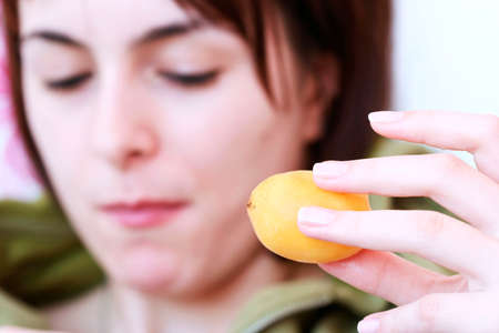 Women eating fresh yellow apricot .の写真素材