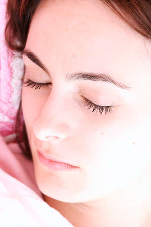Beautiful young woman sleeping on bed in her bedroom at home in the morning.の写真素材