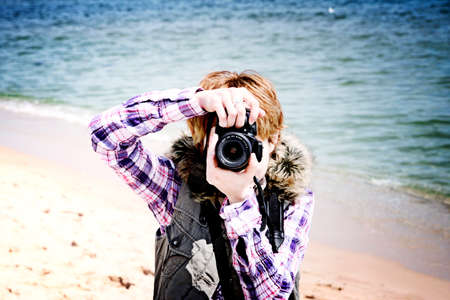 Young photographer making pictures on the beach.の写真素材