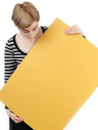 Young blonde woman holding a blank piece of paper.
