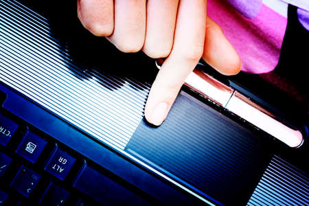Closeup of woman's hand working at laptop.の写真素材