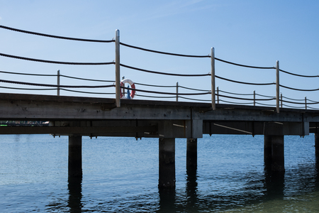 Sea bridge with cable railing and a ring buoyの写真素材