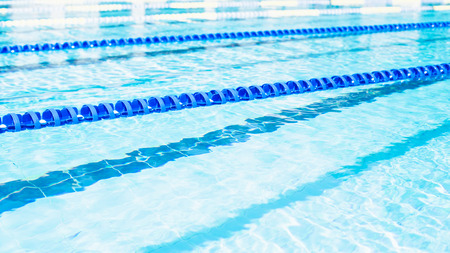 Swimming lanes with clear blue water in public swimming pool in summerの写真素材