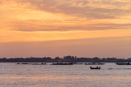 Fishing boat sailing between mussel aquaculture rafts at dusk in Arousa Estuaryの写真素材