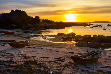 Fishing boats on Abilleira beach at sunset in Arousa Islandの写真素材