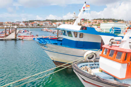 Fishing boats moored on the dock of Xufre harbor in Arousa Islandの写真素材