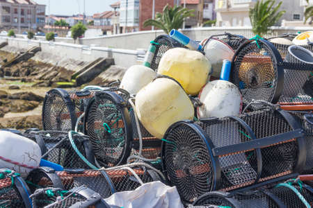 Fishing creels and their buoys stacked on the dock of Naval harbor in Arousa Islandの写真素材