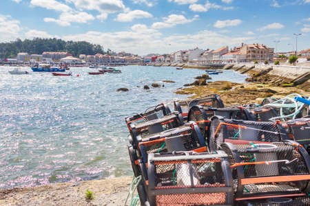 Fishing creels, boats and Cantinho boardwalk in Arousa Islandの写真素材