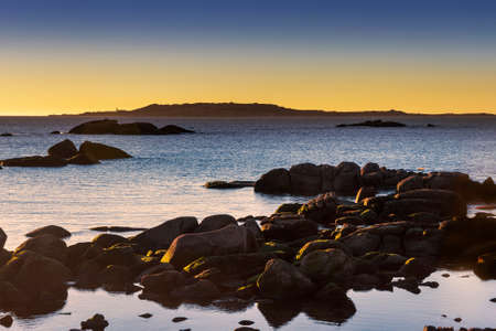 Salvora Island in Atlantic national park at dusk with coastal roks in foregroundの写真素材