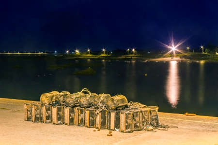 Fishing creels on the dock of Cabodeiro harbor, Arousa Island, at nightの写真素材