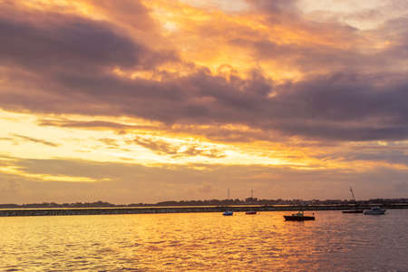 Anchored boats at golden and stormy dusk in Vilanova de Arousa harbor, Spainの写真素材