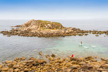 Practicing paddle surf in Lanzada islet, Sanxenxo town, Galiciaの写真素材
