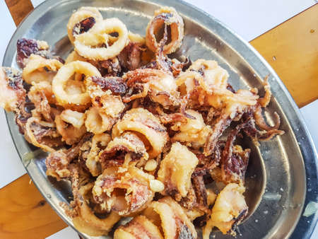 Breaded squid slices on metal trayの写真素材