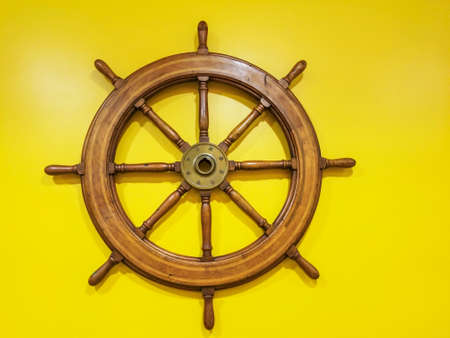 Rudder wheel in yellow background