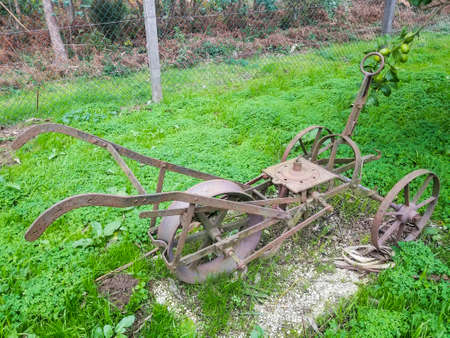 Old iron plow with wheels used in the past as a tool in agricultureの写真素材