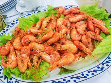 Cooked shrimp Palaemon serratus served on tray over lettuce leavesの写真素材
