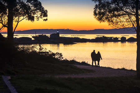 Walking at golden dusk along to Punta Cabalo lighthouse path in Arousa Islandの写真素材
