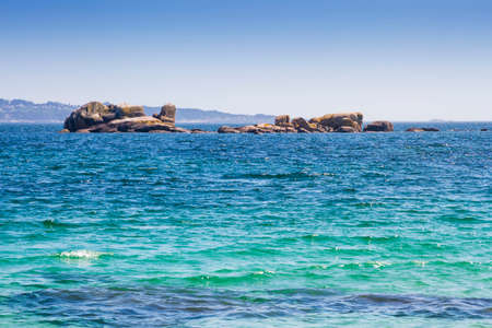 Granite rocky islet on the blue sea of Arousa Estuaryの写真素材