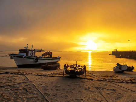 Beached fishing boats at golden dawn on Furado beach in Arousa Island, Galicia, Spainの写真素材