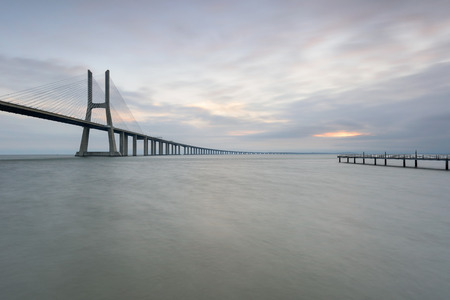 Urban landscape at sunrise. Lisbon is an amazing tourist destination. The Vasco da Gama Bridge is a beautiful landmark, and one of the longest bridges in the world. Portugal in a dawn light.の写真素材