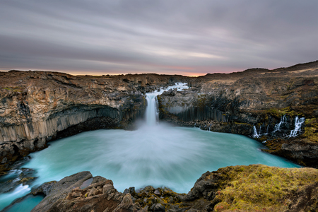 Aldeyjarfoss waterfall in Iceland at sunrise with golden clouds in the sky. Amazing landscape in beautiful tourist attraction. Wonder of nature with glacier water.の写真素材