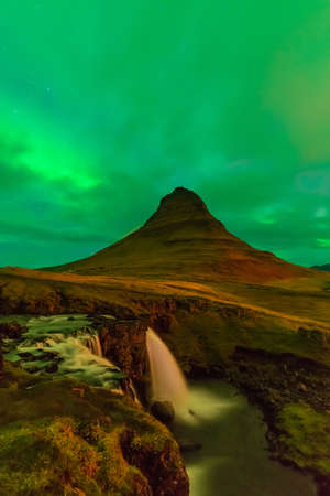 Northern lights in Iceland. Landscape full of kp5 Aurora Borealis. Amazing nightscape at Kirkjufell, scenic travel destination. Green sky full of stars.の写真素材