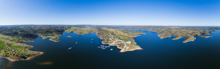 Aerial view of Alquena lake in Alentejo, Portugal. It offers sandy shores, tranquil waters, and scenic beauty, ideal for relaxation and outdoor activities.の写真素材