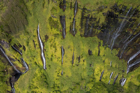 Azores scenic aerial drone landscape, Flores island. Iconic lagoon with several waterfalls on a single rockface, flowing into lake Alagoinha. Best travel destination in Portugal.の写真素材