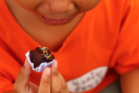 Little boy eating chocolate ball yummy,outdoorの写真素材