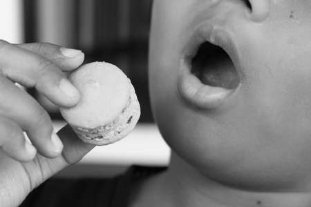 A Boy eating colour French macaroonの写真素材