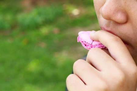 A Boy eating colour French macaroon