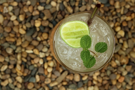 Lemon juice in a glass on a background of rock.