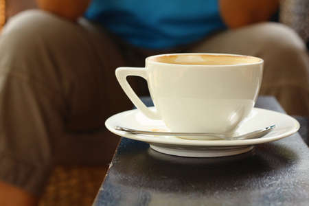 A cup of hot cappuccino coffee in the wood table