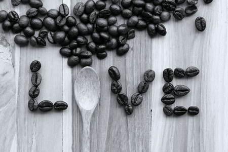 The word love written with coffee beans on wood backgroundの写真素材